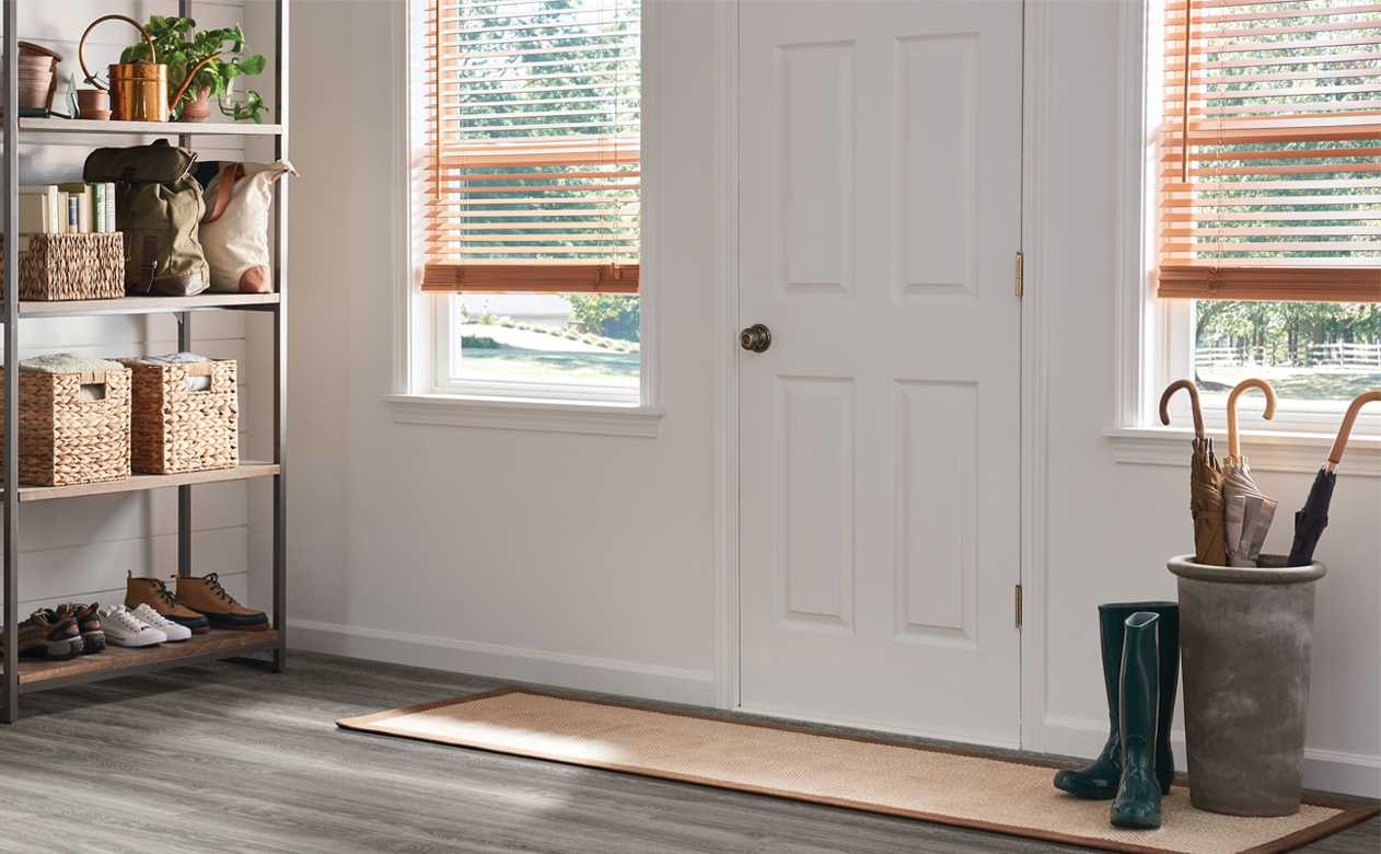 light wood look blinds in window by front door entryway with laminate wood look floors
